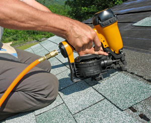 a technician repairing an asphalt shingle roof