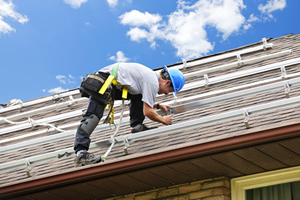 a roofing technician inspecting a roof on a home